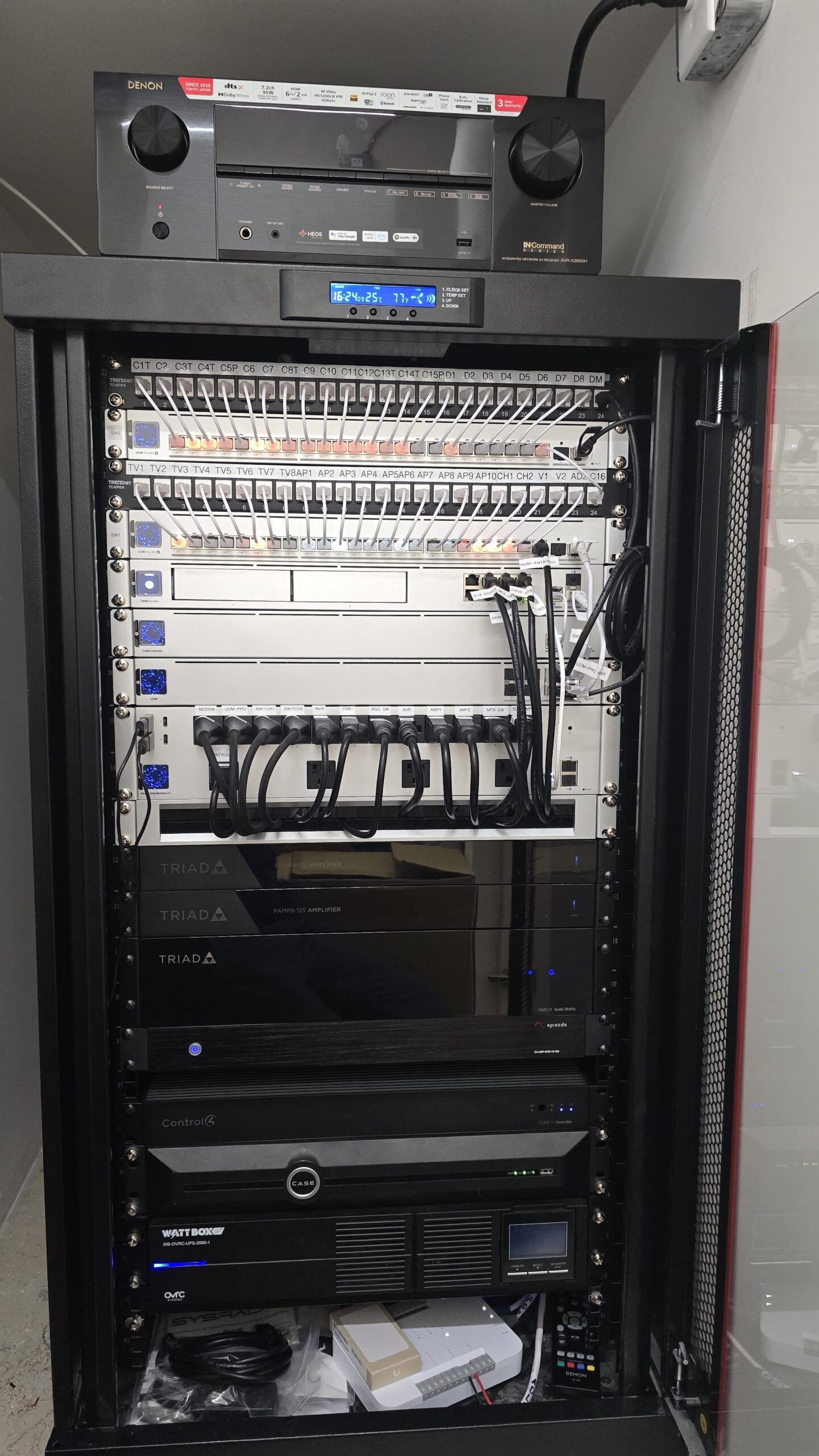 Tall professional network equipment rack with organized connections and installed hardware