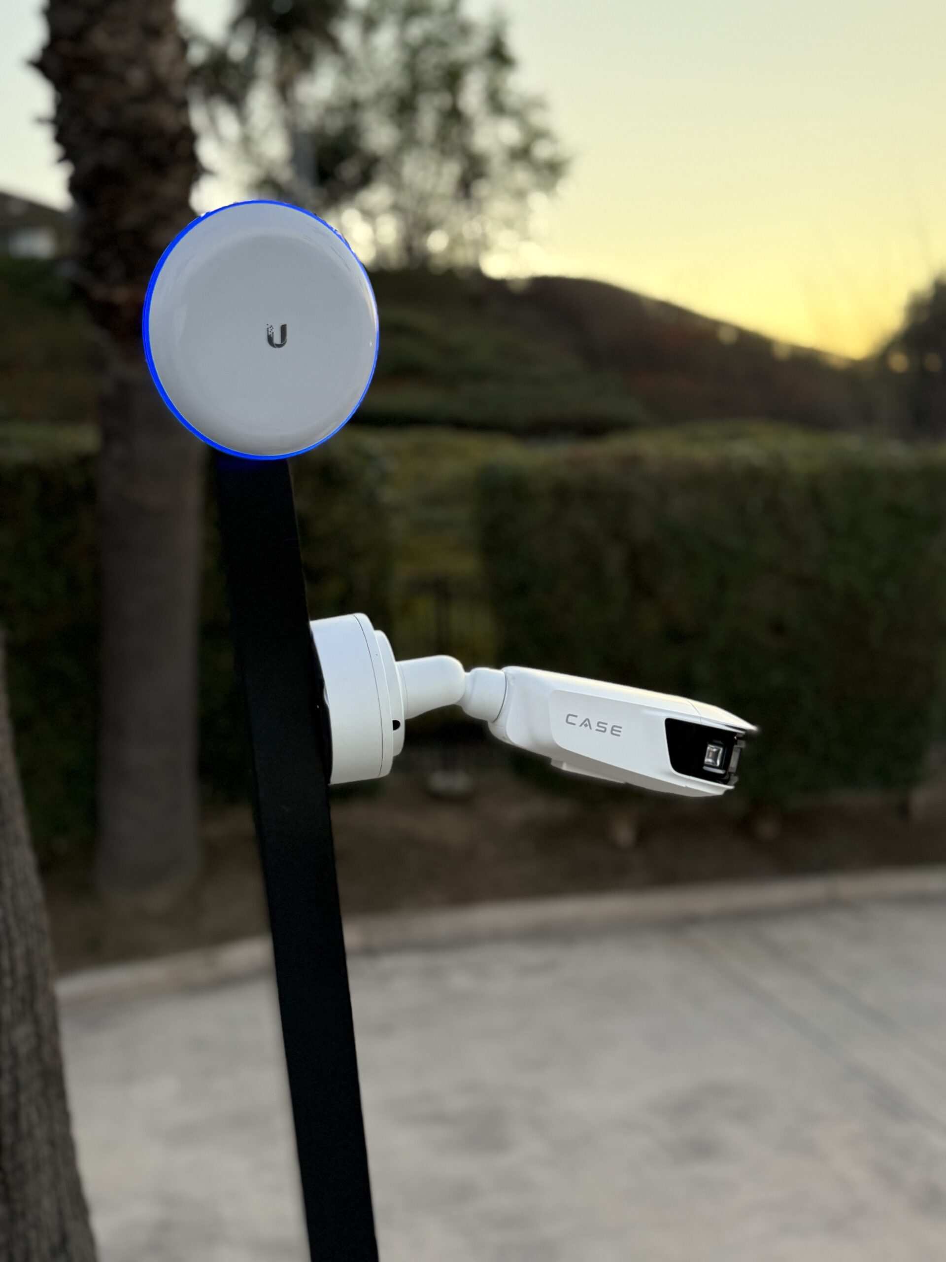 Outdoor UniFi wireless access point mounted near a network security camera
